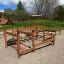 Structure de terrain de jeu extérieure en bois avec éléments d'escalade et d'exercice pour enfants et adultes.