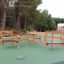 Parcours d'obstacles de terrain de jeu en bois avec cordes d'escalade et plateformes.