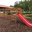 Structure de jeu en bois avec Activity Center with Slide dans un parc.