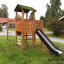Climbing Kiosk Modern Nature wooden playhouse with slide dans une cour arrière verdoyante