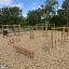 Horizontal Wooden Ladder Nature sur une aire de jeux pour enfants entourée de copeaux de bois.