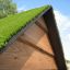 Small House Grass Roof avec structure en bois dans un cadre extérieur ensoleillé.