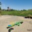 Single Seesaw dans une aire de jeux sablonneuse avec une colline herbeuse en arrière-plan.