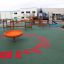 Équipement de jeu orange Flying Saucer sur surface verte avec d'autres structures de jeu en arrière-plan
