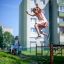 Fille sautant par-dessus l’équipement de jeu Trapezoidal dans un quartier résidentiel.