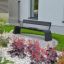 Moderne Sydney Bench dans un jardin paysager avec des fleurs et de la verdure.