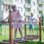 Des enfants jouent sur la structure de jeu Chain Bridge dans un parc.
