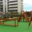 Aire de jeux pour enfants avec structures d’escalade en bois, un pont et un toboggan en milieu urbain, Chain