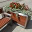 Oxford Flowerpot en bois et métal, rempli de fleurs rouges et de plantes vertes, placé à côté d'un 