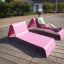 Homme se relaxant sur un Lounge Sofa rose en extérieur.