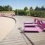 Chaises Lounge Sofa roses sur une promenade en bois au bord de la plage.