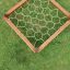 Vue aérienne du filet d’escalade Honeycomb dans un cadre en bois sur l’herbe.