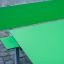 Table HPL vert avec un ensemble de banc assorti vert sur un pavage en pierres de taille.