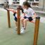 Deux filles jouent sur les barres de fitness Somersault Double dans une aire de jeux.