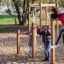 Enfants jouant sur l'équipement de terrain de jeu Somersault Triple dans un parc