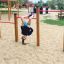 Enfant suspendu la tête en bas sur le Somersault Triple dans un terrain de jeu.