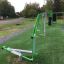 Cross Trainer extérieur sur une zone de fitness herbeuse avec des arbres autour et un chemin de gravier.