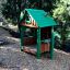 Maison de jeu en bois pour enfants avec toit vert par Nill's Playhouse.