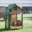 Structure de jeu en bois Nill's Playhouse pour enfants sur une aire de jeux herbeuse