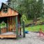 Structure de jeu extérieure en bois Nill's Playhouse pour enfants dans un parc.