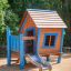Maison de jeu en bois Olle's Playhouse avec des accents bleus et un toboggan dans une aire de jeux