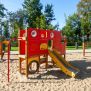 Big Truck single slide, structure de jeu rouge et jaune avec toboggan sur un terrain de sable.