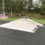Rampe de skatepark appelée Fun Box 8 entourée de verdure.