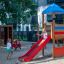 Bird Nest Swing with Tower (BNS 120 cm) single slide en utilisation dans une aire de jeux avec des enfants qui jouent.
