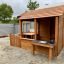 Cabane de jardin en bois avec clôture.