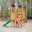 Structure de jeu extérieure Mini Play Modern Nature avec toboggan et échelle dans un parc boisé.