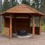 Wooden Wall to Gazebo Shelter dans une clairière forestière.