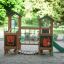 Forest Treehouse playhouse with slide sur une aire de jeux sablonneuse entourée de verdure