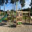 Équipement de aire de jeux Forest Castle with slide dans un parc