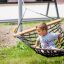 Enfant assis dans Double Hammock (Metal) à l'extérieur.