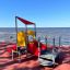 Structure de jeu inclusive rouge et jaune All Accessible Mars Playground au bord de la mer