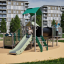 Équipement de jeu Fortress with a slide avec des enfants jouant à l’extérieur dans un quartier résidentiel