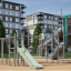 Alpha Centauri structure de terrain de jeu avec toboggan et éléments d’escalade dans un parc urbain moderne.