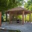 Pavillon extérieur en bois Firehouse dans un cadre naturel et verdoyant de parc.