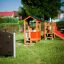 Aire de jeux pour enfants avec une maisonnette en bois, un toboggan et Hidden corner steel structure.