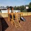 Fortress Nature playhouse with slide dans une aire de jeux.