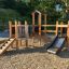 Fortress Nature playhouse with slide dans un cadre de terrain de jeux