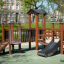 Fortress Nature playhouse with slide dans une aire de jeux extérieure