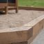Fortress Nature playhouse with slide dans une zone de bac à sable en bois