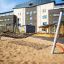Hammock dans une aire de jeux avec un bâtiment scolaire moderne en arrière-plan