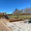 Structure en bois Sandpit avec toboggan et escalier d’escalade dans une aire de jeux extérieure.