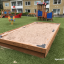 Sandpit dans une aire de jeux située devant des immeubles résidentiels