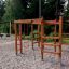 Chimpanzee wooden playhouse dans une aire de jeux entourée d'arbres.