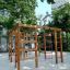Chimpanzee wooden playhouse dans une aire de jeux entourée d'arbres.
