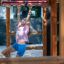 Une fille jouant sur un Chimpanzee wooden playhouse.