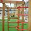 Maison de jeu en bois Activity Center avec structures d’escalade et toboggans.